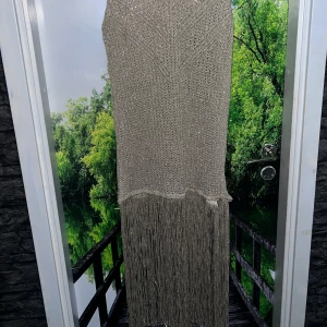 Zara glitterklänning i champagne  - Glittrande champagnetonad stickad klänning från Zara. Midilång, lätt genomskinlig med ett elegant fall. Perfekt att bära med något under för en stilren, festlig look. Aldrig använd – prislappen sitter fortfarande kvar.  Obs! Det finns en liten skada på klänningen: på vänster sida, där glittriga trådarna börjar, har en liten del lossnat från sömmen. Märkte efter jag köpte det . Det är inget stort och går enkelt att sy tillbaka om man vill. Denna klänning har aldrig kommit till användning 