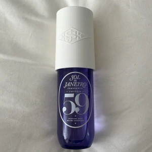 Sol de Janeiro Cheirosa 59 Perfume Mist - Fräsch parfymmist från Sol de Janeiro i modellen Cheirosa 59. Flaskan är lila med en stor vit kork och har en modern, rundad form. Perfekt för dig som gillar trendiga dofter och snygg design på badrumshyllan. Testad en gång 