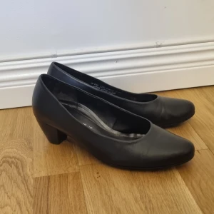 Svarta pumps från Gabor Comfort - Klassiska svarta pumps från Gabor Comfort i skinn med rund tå och låg klack. Snygg och tidlös modell som passar till många olika outfits. Classy skor man kan jobba eller gå långa sträckor i. Aldrig använda då jag köpte gel storlek. Storlek 40