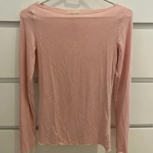 Ljusrosa långärmad topp - En enkel och stilren ljusrosa långärmad topp från missäy . Tillverkad i mjuk bomull med en rak passform och rundad halsringning. Perfekt att matcha med jeans eller kjol för en clean look.