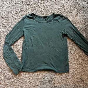 Grön långärmad tröja från Zara - Enkel och stilren grön långärmad tröja från Zara i mjuk bomull. Tröjan har rund halsringning och en rak passform