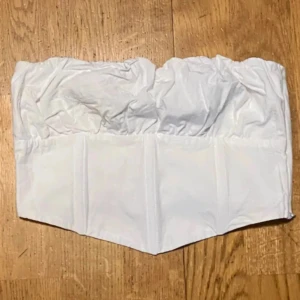 Vit topp från Bershka!  -  Säljer en stilren vit korsettopp.  Perfekt för varma sommardagar eller som en del av en lager-på-lager-look. Köpt på Zalando och är aldrig använd. 