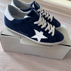 Golden Goose - PRESENTERAR: 2025 års modell av Golden Goose mörkblå superstars💫Använda typ 4ggr dvs skick 10/10 allt OG ingår (ej kvitto dock) SJÄLVKLART ÄKTA! Storlek 42 (Fits 41-42) MYCKET SVÅRA ATT HITTA PÅ MARKNADEN! Nypris: 6000kr Hör av er vid frågor⁉️