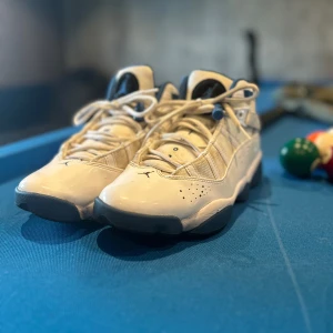 Nike Jordan 6 Rings vit/blå sneakers - Nike Jordan 6 Rings sneakers i vitt och blått med klassisk Jumpman-logga på plösen och yttersulan. Skorna har snörning, mesh och skinnpaneler samt vadderad blå insida. Snygg och sportig design med rund tå och platt sula.