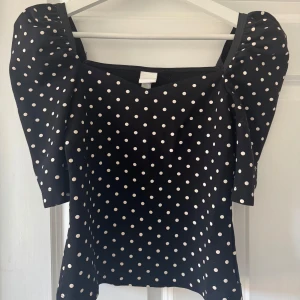 Svart prickig topp med puffärm - Trendig HM topp!! Super snygg och passar till massvis olika sammanhang🥰🥰Kommer tyvärr inte längre till använding😓