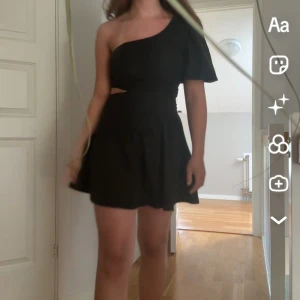 Svart oneshoulder kortklänning - Snygg svart kortklänning med oneshoulder-design och lätt utställd kjol. Klänningen har en cool cut-out detalj vid midjan och klänningen är från Shein men bra kvalité🩷