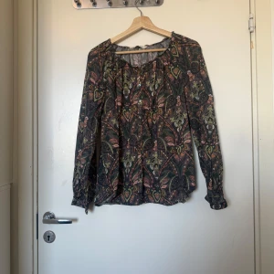 Odd molly skjorta  - Säljer en superfin mörkgrön skjorta med ett detaljerat mönster i bland annat, grönt, orange, rosa och grå. Från märket Odd Molly i storlek 2 som ungefär motsvarar en Storlek M. Fint skick men kan vara något blekare än ny. 
