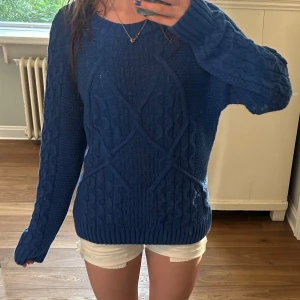 Blå stickad tröja från b.young - Ny pris 600. Använd en gång (till bilden). Säljer en blå stickad tröja från b.young med snyggt kabelstickat mönster och ribbade muddar. Tröjan har rund halsringning och långa ärmar, perfekt för lager på lager under kyliga dagar.
