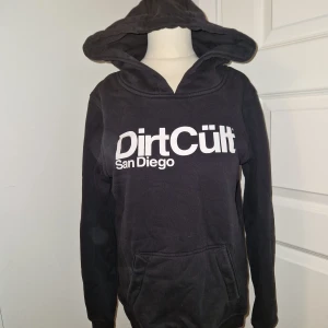 DirtCült San Diego - Knappt använd hoodie från Dirtcult. Endast legat och tagit plats.  Ej urtvättad.  Storlek M, dam. Jag upplever den vara mindre än M. Tröjorna är allmänt kända att vara mindre än själva storleken.  Inget snöre i hoodien.  Ligger ute på fler sidor.
