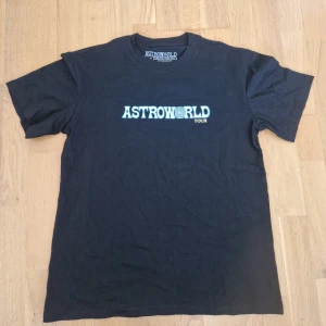 Astroworld Tour t-shirt  - Svart Astroworld Tour t-shirt i bomull med tryck fram och bak. Framsidan har Astroworld-loggan i blått och gult, baksidan har stor grafik av Travis Scott, turnédatum och röd text 'Wish you were here'. Klassisk passform och rund hals. Helt ny!! Aldrig använd!!