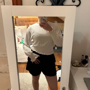 Vit ribbad tröja från H&M Divided XS - Supersöt vit ribbad tröja från H&M Divided i storlek XS. Tröjan har långa ärmar, smockad midja och ärmar samt volangdetaljer vid muddar och nederkant. Perfekt för dig som gillar en feminin och trendig stil.