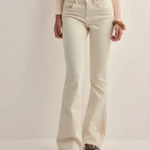 Beiga bootcut jeans från Vero Moda - Snygga beiga jeans från Vero Moda i modellen Flash. Byxorna har bootcut-ben, klassisk femficksdesign och midwaist. Tillverkade i mjuk bomullsdenim med en stilren look som passar till allt. Perfekta för dig som gillar en clean och trendig vibe.
