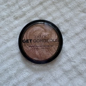 Technic Get Gorgeous Highlighter - Bronze highlighting powder från Technic i nyansen Get Gorgeous. Ger en snygg glow med skimrande finish. Kommer i en rund dosa med svart lock och innehåller 6g. Vegansk formula, perfekt för att framhäva kindben och ge extra lyster.