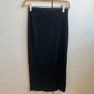 Ribbad långkjol med slits - En svart, ribbad långkjol med slits på sidan