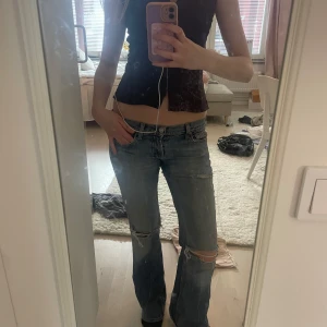 Lågmidjade slitna bootcut jeans -  blå lågmidjade  bootcut jeans . Jeansen har slitningar och hål vid knäna. Bra skick!!☺️☺️🩵🩵🩵