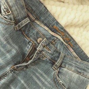 Blå lågmidjade bootcut jeans med orange sömmar - Säljer ett par jeans 