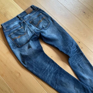 Nudie jeans grim Tim 31/34 - Säljer ett par feta nudie jeans i den populäraste modellen grim Tim! Storleken är 31/34! Bra skick men ett hål i högra fickan! Jätte snygg tvätt ⚜️skriv vid funderingar!