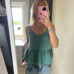 Grön linnetopp med volang - Snygg grön linnetopp med volang nertill och smala axelband. Superfin till sommaren!🌸☀️