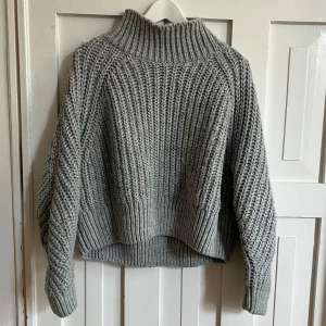 Grå stickad tröja från H&M - Säljer en grå stickad tröja från H&M med hög krage.