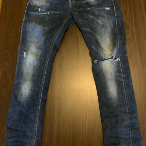 Blå slitna jeans från Dondup - Säljer ett par blå jeans från Dondup, modell George. Jeansen har slitna detaljer.