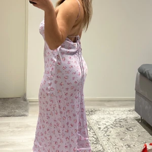 Ljuslila blommig långklänning från Zara - Supersöt långklänning från Zara i ljuslila med små rosa och lila blommor. Klänningen har smala axelband och är ärmlös. 