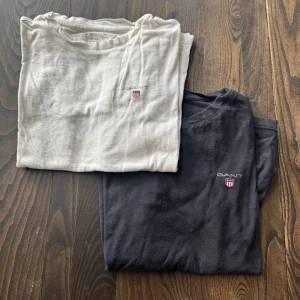 2-pack GANT t-shirts  - Säljer två klassiska t-shirts från GANT, en svart och en vit. Säljer tillsammans som ett paket men man kan även köpa separat om man vill det. Skriv till mig om ni har några frågor!