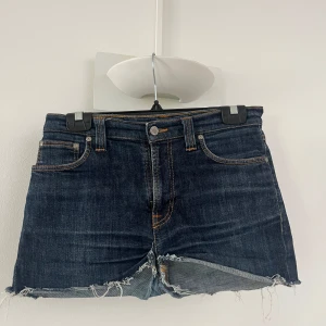 Mörkblå jeansshorts från Nudie Jeans Co - Snygga mörkblå jeansshorts från Nudie Jeans Co. Säljer pågrund av att dom är förstora för mig i midjan, är xs/s. Dom är högmidjade och såååå sköna, och dom får rumpan se mycket större ut! Om dom hade passat hade jag absolut haft kvar dom! Så snygga till tex stickad tröja! Vet tyvärr ej storlek men skulle gissa att de skulle passa någon s/m kanske!