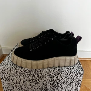 Svarta sneakers med tjock sula - Säljer ett par svarta sneakers med kraftig, beige platt sula och snörning. Skorna har rund tå och är perfekta för dig som gillar en chunky stil. Passar till många olika outfits och är riktigt bekväma.