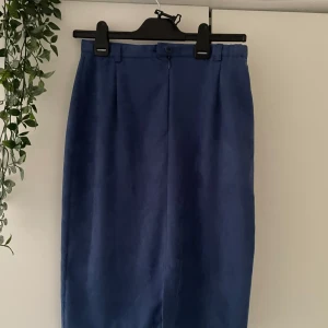 Blå pennkjol  - Säljer en stilren blå pennkjol  med hög midja och minimalistisk design. Kjolen har en rak passform och är perfekt för dig som gillar en clean look. Passar till många olika outfits! Erroll finns ej med motsvarar XS/S