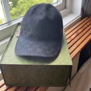 Gucci Keps svart canvas - Fin gucci keps skick 7/10 finns alltid mer bilder om behövs eller om ni har några fler frågar, Har inte kvar alla tillbehör till den boxen har rivits sönder på toppen men de är fast med magneten i den äkta 100% finns ej kvitto, Den som kan äkta vet direkt! säljer pga pengar