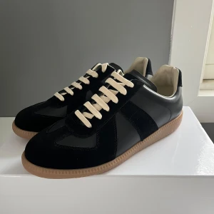 Svarta sneakers från Maison Margiela GATS - Säljer ett par feta gats från maison margiela. Original box tillkommer. Obs : ni vet varför de e så billiga Ni kan gärna höra av er om ni har några funderingar.