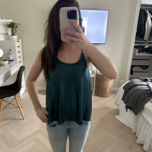 Festtopp i blå grön färg glittrig - Jätte fin festtopp. Helt ny me lapp. Köpt fårn sellphy men den va aldrig använd därifrån heller och även den oeginala lappen sitter kvar på. Storlek XS. Orginalpis är 250 kr. Noisy may är märket. 