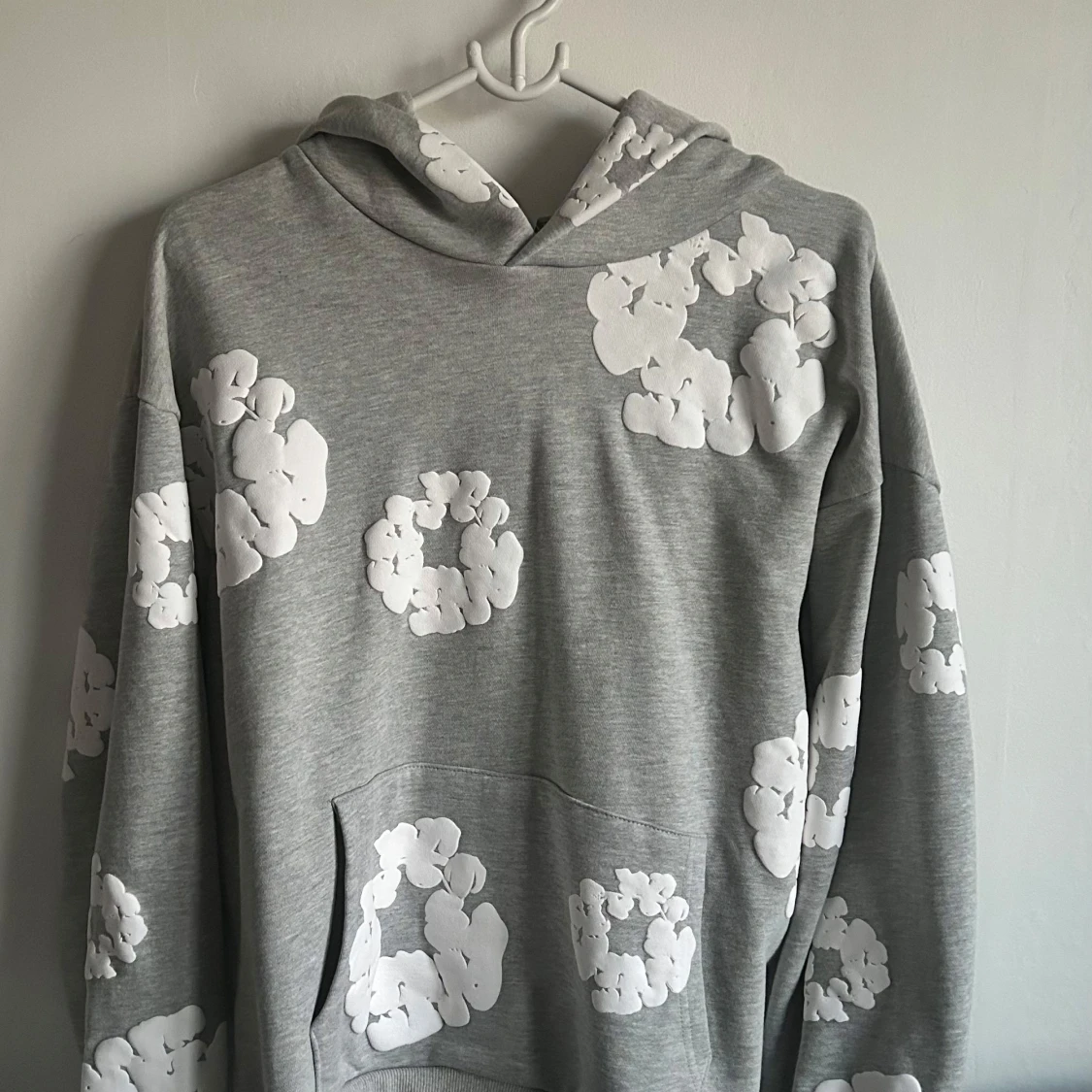 Grå hoodie med vita blommönster från Denim Tears