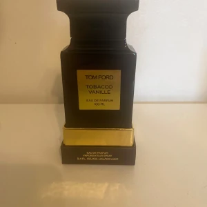 Tom Ford Tobacco Vanille Eau de Parfum 100 ml - Lyxig parfym från Tom Ford i doften Tobacco Vanille. Flaskan är svart med guldiga detaljer och rymmer 100 ml. Kommer i originalförpackning. En ikonisk och elegant doft med inslag av tobak och vanilj.