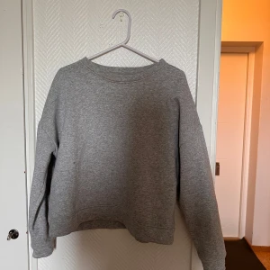 Grå sweatshirt från Pieces - En enkel och stilren grå sweatshirt från Pieces. Tröjan har rund halsringning, långa ärmar och en klassisk passform. Perfekt för en avslappnad och bekväm stil.