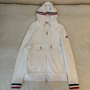 Moncler hoodie - Säljer en vit Moncler hoodie i mycket bra skick. Storlek L men passar M också. Hör av er vid fler frågor