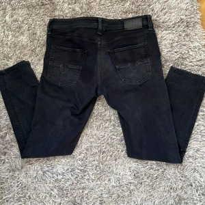 Svarta Diesel Larkee-Beex jeans - Svarta jeans från Diesel, modell Larkee-Beex Tapered. Klassisk femficksdesign med snygga bakfickor och diskret Diesel-logga. Jeansen har en avsmalnande passform och är tillverkade i ett mjukt bomullstyg med stretch för extra komfort.