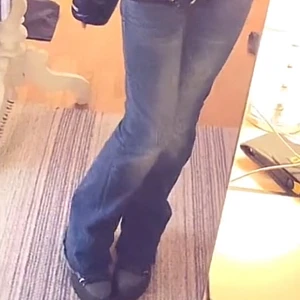 Blåa True Religion Joey Jeans W24 - Säljer ett par blå bootcut jeans med snygga kontrastsömmar och dekorativa fickor bak. Jeansen har klassisk femficksdesign, låg midja och är tillverkade i jeansmaterial. Perfekta för dig som gillar en retroinspirerad look med extra detaljer.