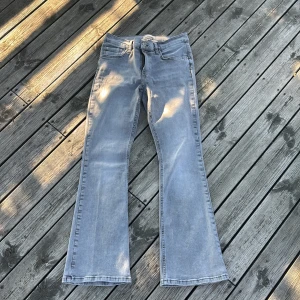 Grå bootcut jeans från Perfect Jeans - Snygga grå jeans från Perfect Jeans i bootcut-modell. Jeansen har klassisk femficksdesign, normalhög midja och är tillverkade i mjukt denimtyg. Perfekt för dig som gillar en avslappnad men trendig look.