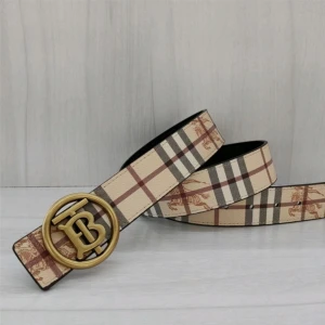 Rutig Burberry bälte med TB-spänne - Snyggt bälte från Burberry i klassiskt beige, brunt och svart rutigt mönster med ikoniska hästmotiv. Bältet har ett stort TB-spänne i metall, finns i både guld- och silverfärg. Tillverkat i skinn och perfekt för att lyfta vilken outfit som helst.