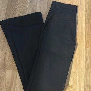 Svarta kostymbyxor från Zara S - Snygga svarta kostymbyxor från Zara i storlek S. Byxorna har raka ben, bälteshällor och klassisk passform. Perfekta till en stilren look och tillverkade i ett mjukt tyg som känns bekvämt hela dagen.