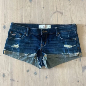 lågmidjade jeans shorts hollister - Snygga mörkblå jeansshorts från Hollister med slitna detaljer och fransig kant. Från 2000-talet 😍😍😍