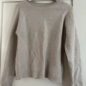 Beige stickad tröja från Vero Moda - Mysig beige stickad tröja från Vero Moda med rund halsringning och ribbade muddar vid ärmslut och nederkant. Perfekt för lager-på-lager och chill höst- eller vinterstil. Enkel att matcha med jeans eller kjol.