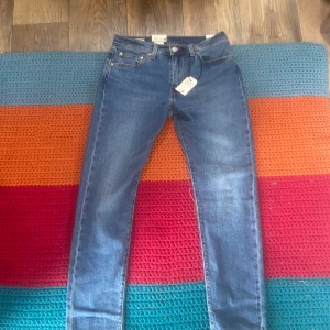 Levi's 512 Slim Taper jeans blå 30/30 - Säljer ett par helt oanvända Levi's 512 Slim Taper jeans i klassisk blå tvätt. Modellen har smal passform med avsmalnande ben och sitter lite under midjan. Jeansen är tillverkade i stretchig bomull för extra komfort och har fem fickor samt läderpatch bak.