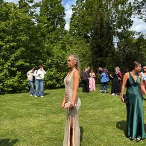 Glittrig champagnefärgad balklänning - Säljer en lång, glittrig balklänning i champagnefärg med v-ringning och smickrande omlottliv. Klänningen har en hög slits framtill och är ärmlös med smala axelband. Perfekt för bal eller student! Materialet är glittrigt och skimrande, vilket ger en lyxig känsla. Köpte den för 2900 på zalando, använd en gång🩷