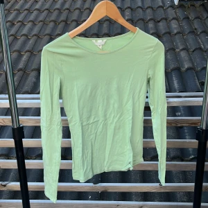 Ljusgrön långärmad tröja H&M - Enkel och stilren ljusgrön långärmad tröja från H&M. Tröjan har rund halsringning och är gjord i mjuk bomull, perfekt för lager-på-lager eller som den är. Passformen är normal och materialet känns lätt och bekvämt mot huden.