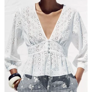 Vit broderad blus med v-ringning - Superfin och eftertraktad vit blus i bomull med broderade hålmönster. Blusen är oanvönd, från Zara och är slutsåld på deras hemsida.❤️