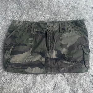 Camo minikjol från Abercrombie & Fitch - Snygg minikjol i camouflage från Abercrombie & Fitch. Köpte den i london förra året och har bara använt 2 gånger. Står ingen storlek i kjolen vad jag kunnat se men skulle säga att den är i S💕
