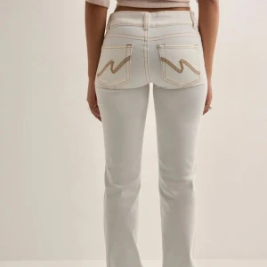 Vita bootcut jeans med kontrastsömmar - Vita jeans från Nelly💕 Säljs pga att de inte kommer till användning har använts endast 2 gånger o är i ny skick🥰