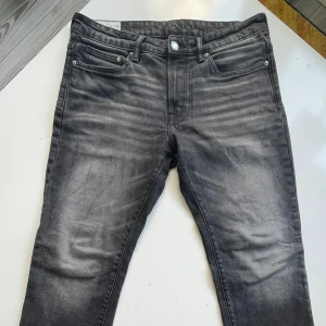 Grå straight fit jeans från H&M - Snygga grå jeans från H&M i straight fit med regular passform. Jeansen har klassisk femficksdesign, normal midja och raka ben. Materialet är mjukt och bekvämt, perfekt för en avslappnad stil. Färgen är tvättad grå med lätt slitning för en cool look.